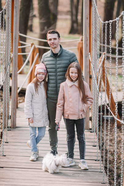Father and cute daughters with dog outdoors - Photo, Image
