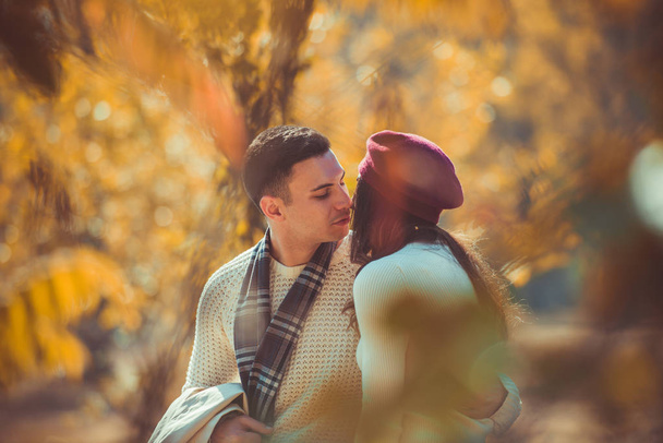 Το όμορφο ζευγάρι κοιτάζει ο ένας τον άλλο ενώ φιλάει στο πάρκο. - Φωτογραφία, εικόνα