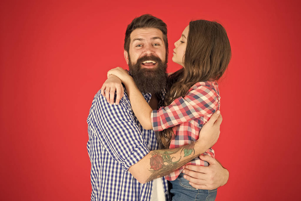 Family values concept. Family bonds. Friendly relations. Father hipster and his daughter. Sweet hug. Man bearded father and cute little girl daughter on red background. Celebrate fathers day - 写真・画像