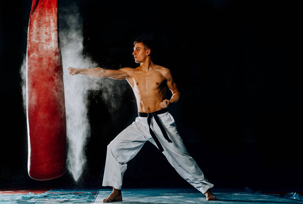 ação de um treinamento de lutador de artes marciais de boxe em um saco de perfuração no ginásio
 - Foto, Imagem
