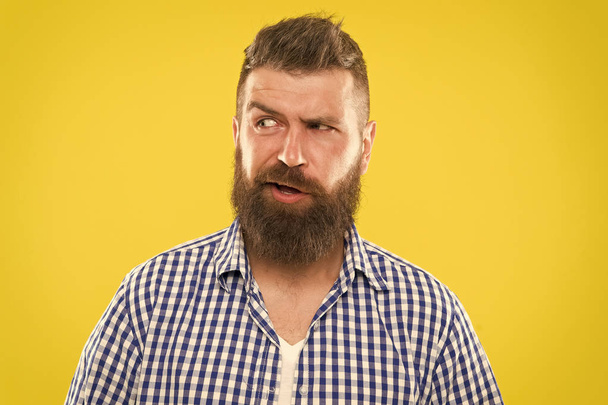 Sounds tricky. Man serious face raising eyebrow not confident. Have some doubts. Hipster bearded face not sure in something. Doubtful bearded man on yellow background close up. Doubtful expression - Φωτογραφία, εικόνα
