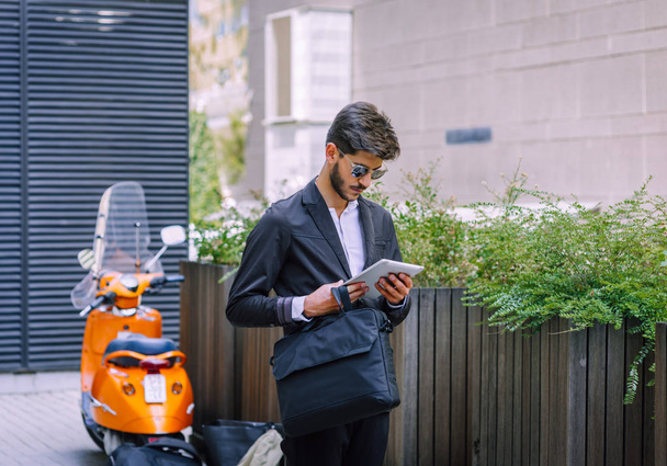 Стильный бизнесмен, читающий онлайн-новости с помощью цифрового планшета - Фото, изображение
