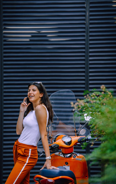 Moda sorridente caucasica donna parlando su uno smartphone in città - Foto, immagini
