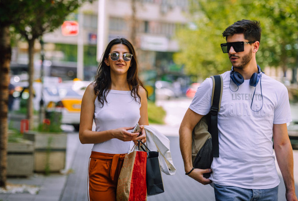 Gelukkige paar met boodschappentassen wandelen en lachen - Foto, afbeelding