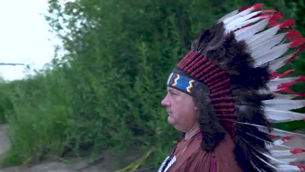 Οι παλιοί Ινδιάνοι ιθαγενών της Αμερικής στέκονται στο φόντο του ποταμού. - Πλάνα, βίντεο