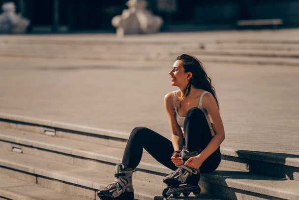 Patinadora femenina relajándose después de patinar en la ciudad
 - Foto, imagen