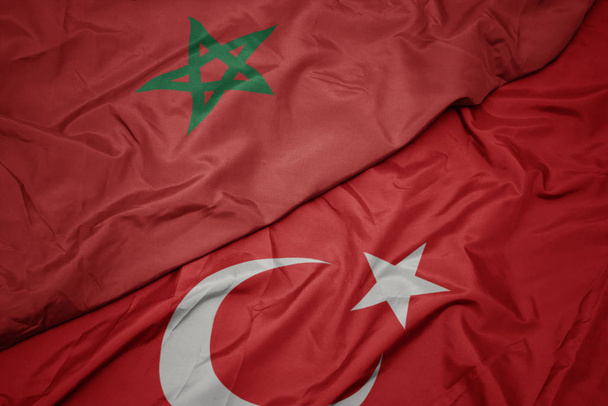 размахивая разноцветным флагом индейки и национальным флагом Марокко
. - Фото, изображение