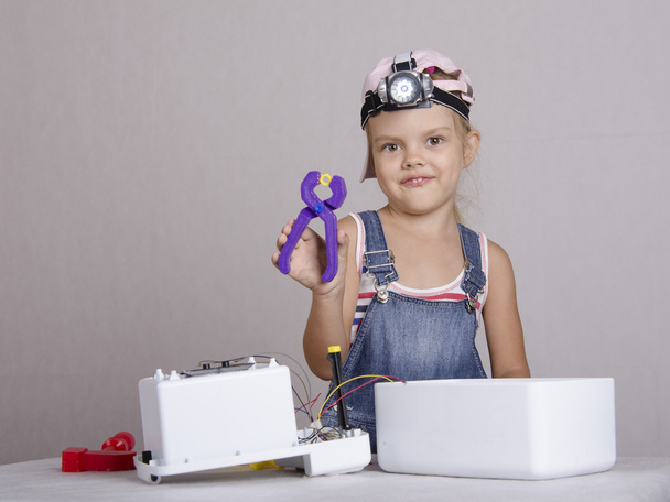 Дівчина ремонтує іграшкові прилади
 - Фото, зображення