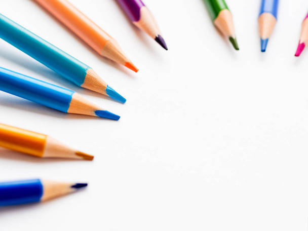 Colorful watercolor pencils on white background. School supplies with round copy space. Kid's stationery. Back to school circle backdrop. - 写真・画像