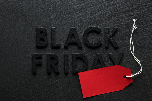 Black Friday text with red sale tag on slate background - Photo, Image