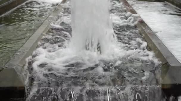 Pieniaste strumienie wody rosną i opadają. Aleja fontann w parku miejskim. Zwolnionym - Materiał filmowy, wideo