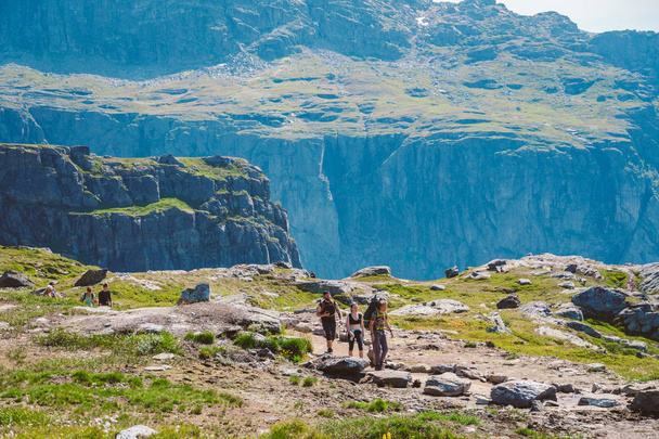July 26, 2019. Norway tourist route on the trolltunga. People tourists go hiking in the mountains of Norway in fine sunny weather to thetrolltunga. Hiking backpack theme - Фото, изображение