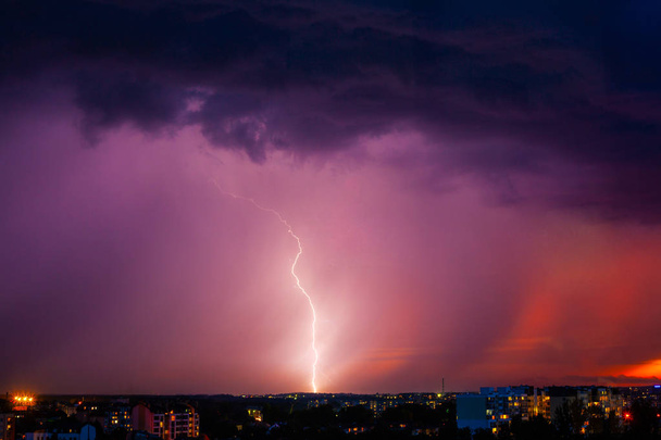 Rayo golpea tormenta sobre la luz púrpura de la ciudad
. - Foto, Imagen