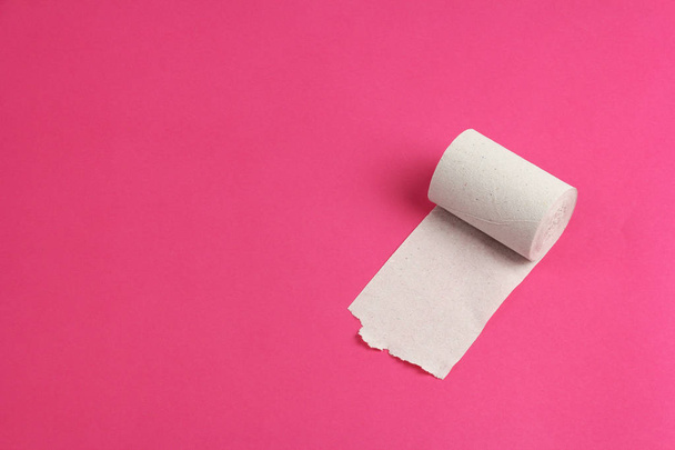 Rolka szorstki biały papier toaletowy na różowym tle, zbliżenie, przestrzeń kopiowania, koncepcja problemów żołądkowych lub biegunka - Zdjęcie, obraz