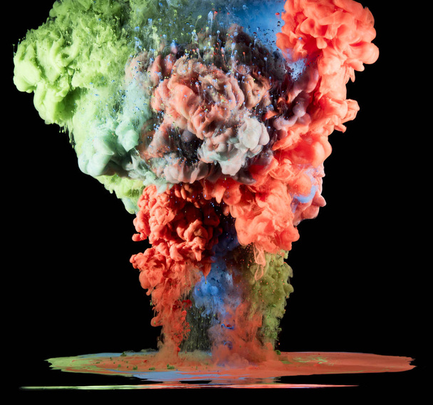Colorful rainbow paint drops from above mixing in water. Ink swirling underwater - Photo, Image
