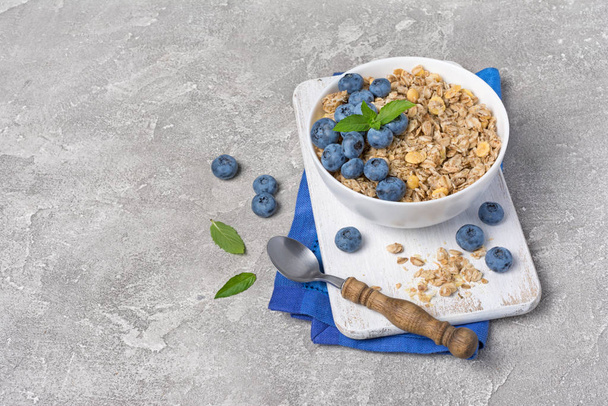 Oat flakes or granola with fresh blueberry for healthy breakfast - Foto, afbeelding