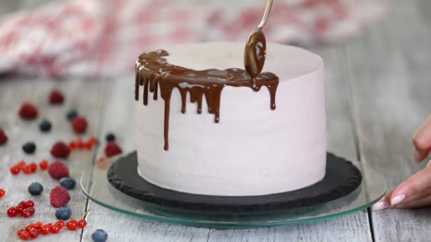Chocolade slagroom op de taart. Witte taart bedekt met chocolade en room. Chocolade cake decoratie. - Video