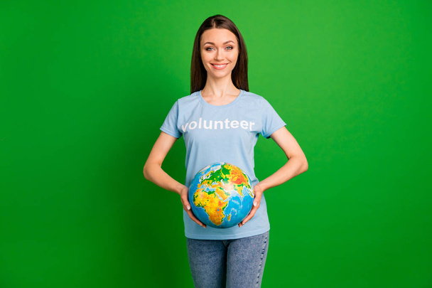 Portrait of her she nice attractive confident cheerful straight-haired girl wearing printed tshirt holding in hands globe geography teacher isolated over bright vivid shine green lime background - Fotoğraf, Görsel