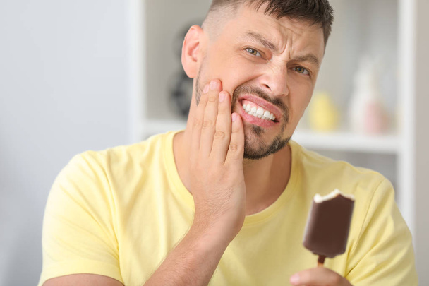 自宅で敏感な歯と冷たいアイスクリームを持つ男 - 写真・画像