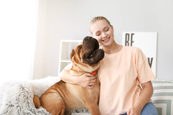 Femme heureuse avec chien mignon à la maison
 - Photo, image