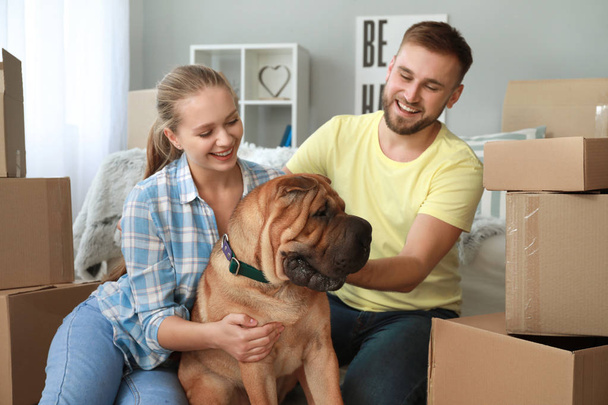 Happy couple with cute dog after moving into new house - Fotografie, Obrázek