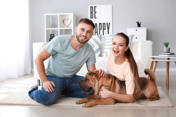 Happy couple with cute dog at home - Fotografie, Obrázek