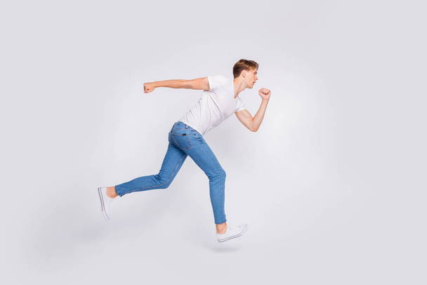 Full length photo of jumping high guy ready to begin race wear casual outfit isolated white background - Foto, afbeelding