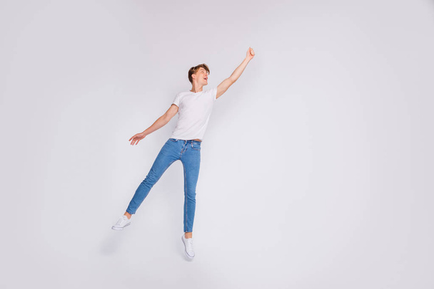 Full body photo of crazy guy jumping high with imaginary umbrella wear casual outfit isolated white background - Fotó, kép