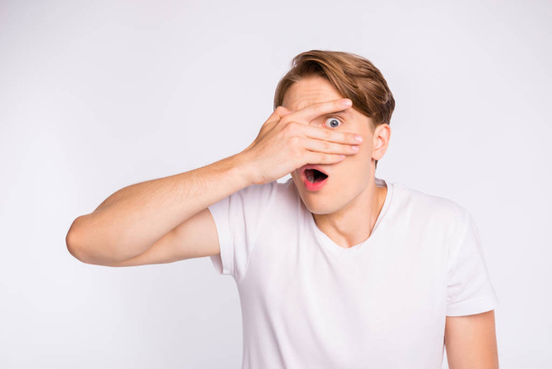 Photo of amazing guy hiding eye with arm watching scary movie wear casual outfit isolated on white background - Foto, afbeelding