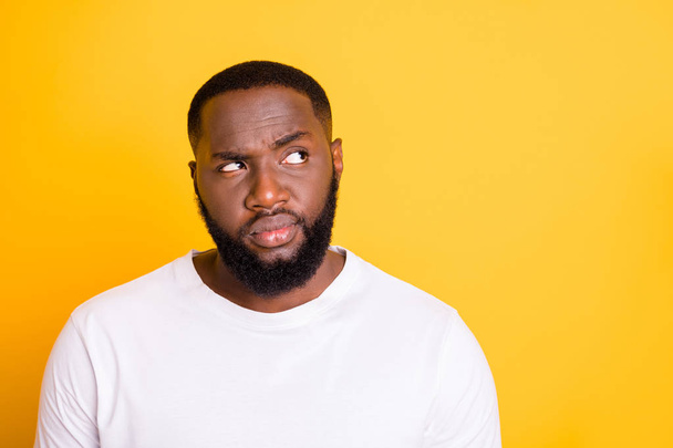 Close up photo of dark skin guy looking up empty space not sure with decision wear casual outfit isolated yellow background - Foto, Imagen