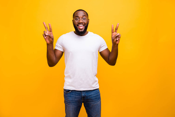 Photo of cheerful nice kind friendly african man showing v-sign looking for friends in new town he has never been to before while isolated with vivid background - Фото, изображение