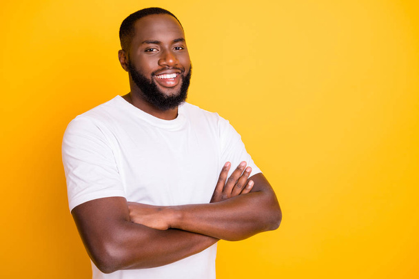 Photo of friendly afro american man standing in front of camera with his hands crossed while isolated with vivid background - Photo, image