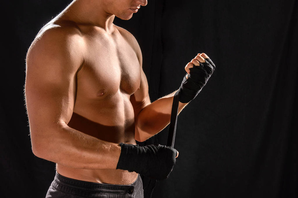  boxer demi nu enveloppant à la main, isolé sur noir
 - Photo, image