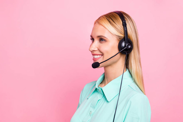 Profile side photo of professional manager having mic listen landline smiling wearing teal shirt isolated over pink background - Zdjęcie, obraz