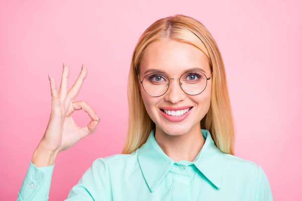 Close up photo of positive promoter showing okay sign smilling wearing mint color shirt isolated over pink background - Foto, imagen
