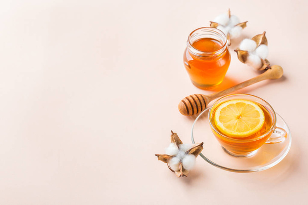 Cup of tea with honey on pastel pink, apricot background - Valokuva, kuva