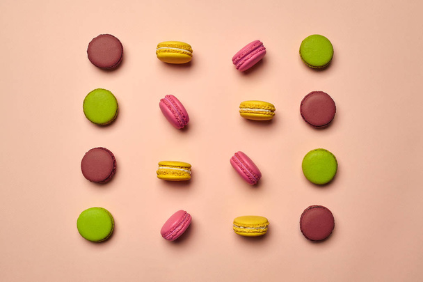 Macaron colorato o macaron, dolce pasticceria a base di meringa su sfondo rosa. Primo piano, copiare lo spazio. - Foto, immagini