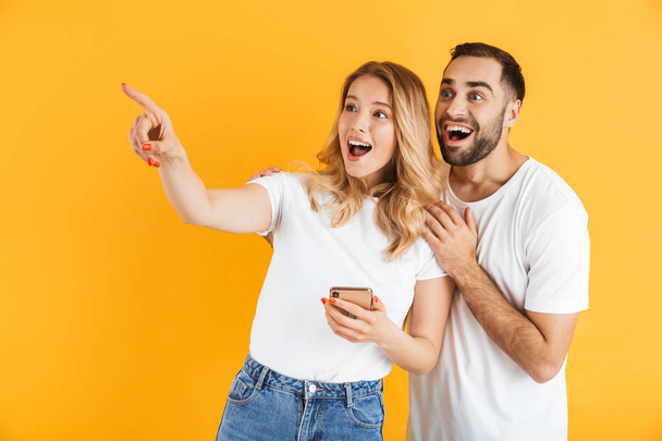 Excited cheerful young couple standing isolated - Foto, Bild