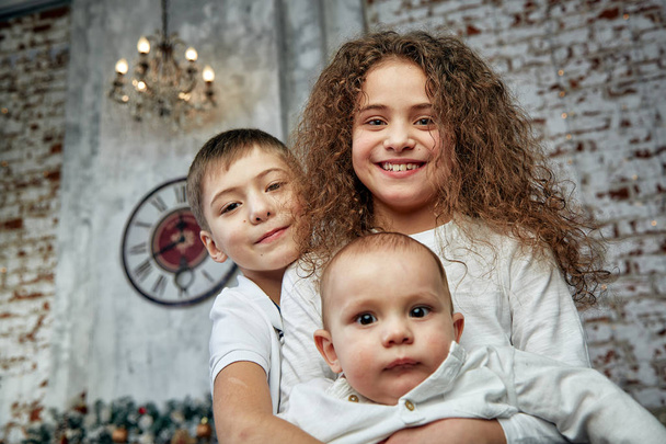Karácsonyi koncepció és a gyermekek vár a csodát. Portré különböző gyerekek a háttérben a karácsonyi dekoráció, előtt 15 perccel karácsony estéjén. Gyermekek karácsony és ajándékok, másolás - Fotó, kép