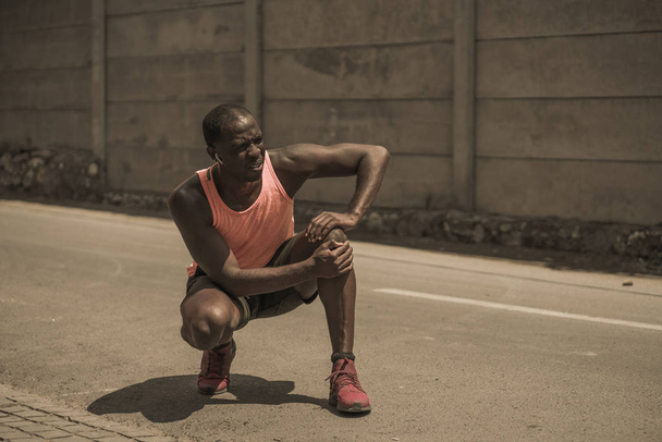jeune athlète et en forme afro noir coureur américain dans la douleur tenant son genou après avoir souffert de problèmes médicaux avec tendon ou ligament blessé pendant l'entraînement de course urbaine
 - Photo, image
