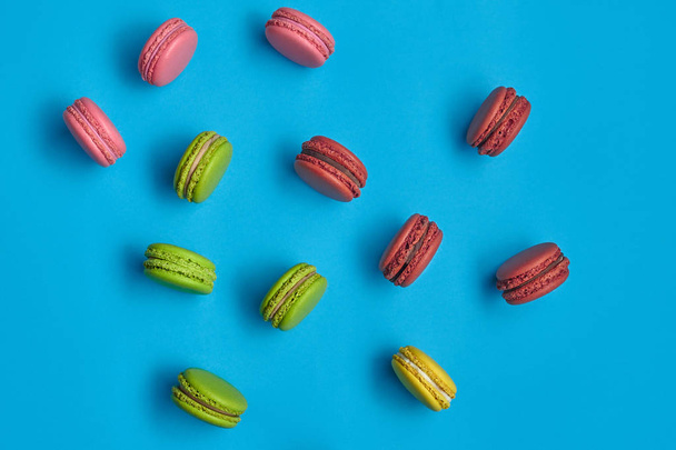 Colored macaron or macaroon, sweet meringue-based confection on blue background. Close-up, copy space. - Фото, зображення