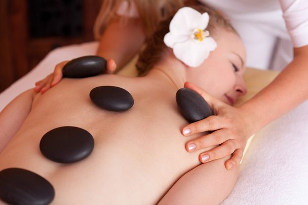 Woman receiving a spa treatment with hot stones - 写真・画像