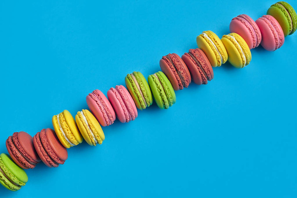 Macaron colorido ou macaroon, doce confeção à base de merengue no fundo azul. Close-up, espaço de cópia. - Foto, Imagem