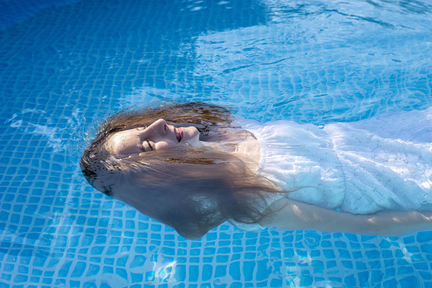 jovem com vestido branco na piscina
 - Foto, Imagem
