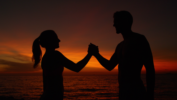 Slow Motion, Close Up, Silhouette: Vrolijke trainingspartners schudden elkaar de hand na zonsondergang. Cinematic handdruk uitgevoerd door gelukkig vriendje en vriendin op een mooie zomeravond. - Video