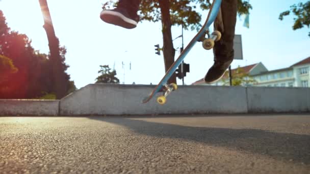 Slow Motion, Lens Flare, Close Up: Neznámý skateboardista skáče a přistane v pohodě trik při jízdě na betonovém chodníku ve slunném městě. Filmový pohled na skateboard, jak se převrací ve vzduchu pod nohama člověka - Záběry, video