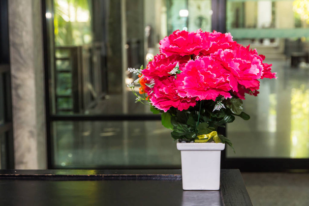 Falešná květina a květinová deska v kanceláři, růžové květiny - Fotografie, Obrázek
