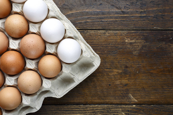 eggs in a tray on a wooden background - Foto, afbeelding