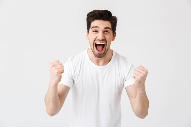 Excited happy young man posing isolated over white wall background. - Foto, Bild
