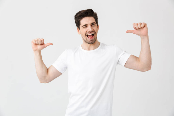 Excited young man posing isolated over white wall background pointing. - Fotoğraf, Görsel